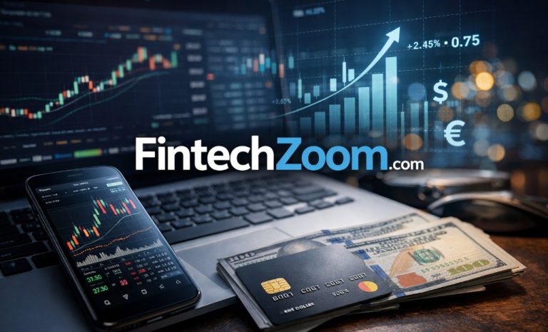 The image showcases the FintechZoom.com logo with a smartphone displaying a trading chart, a laptop with financial data, a credit card, cash, and digital financial elements.